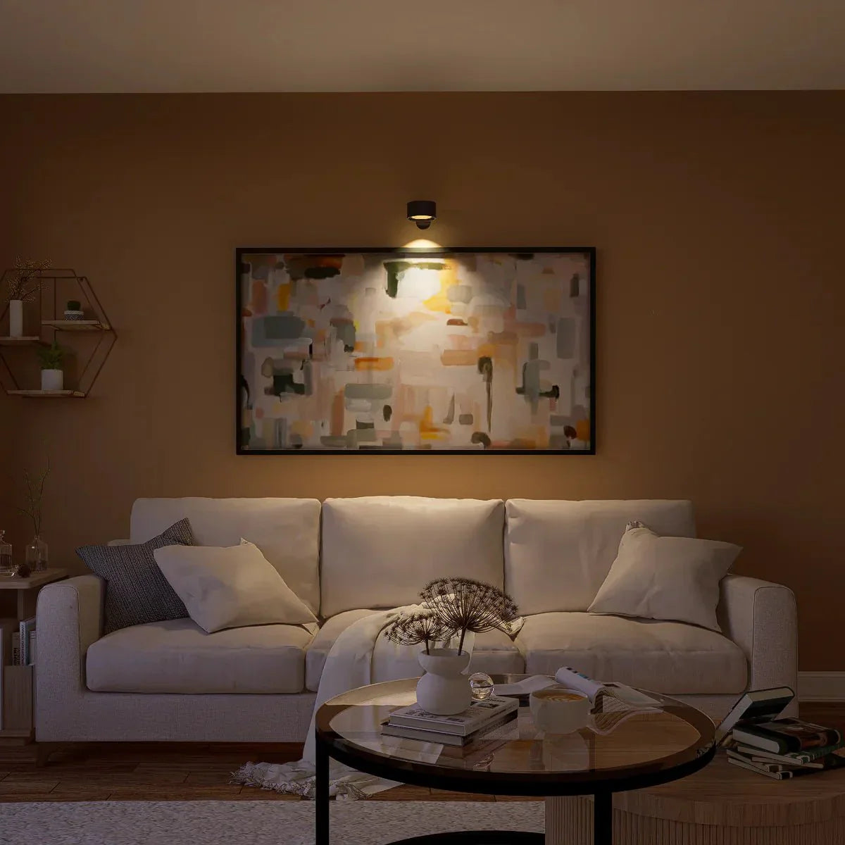 Gezellige woonkamer verlicht door de Aurora Glow draadloze wandlamp, die een warm licht werpt op een kleurrijk kunstwerk boven een comfortabele bank. Deze minimalistische lamp voegt een stijlvolle en functionele touch toe aan de ruimte, ideaal voor een ontspannen sfeer. Perfect voor moderne interieurs.