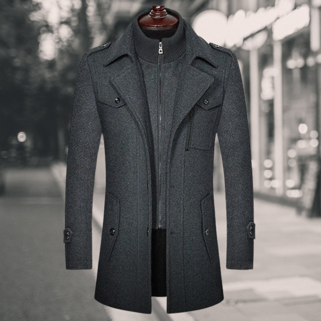 Baysor Lange Winterjas in stijlvol grijs. Deze lange herenjas biedt een verfijnde look met een hoge kraag, rits- en knoopsluitingen, en meerdere praktische zakken. Perfect voor de wintermaanden met een combinatie van comfort en elegantie.