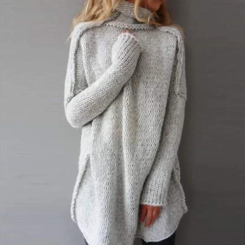 Belenza comfortabele trui in lichtgrijs, met een oversized pasvorm en hoog opstaande kraag. De trui heeft een grof gebreide textuur en lange mouwen, ideaal voor een cosy en stijlvolle winterlook. Perfect te combineren met casual outfits.
