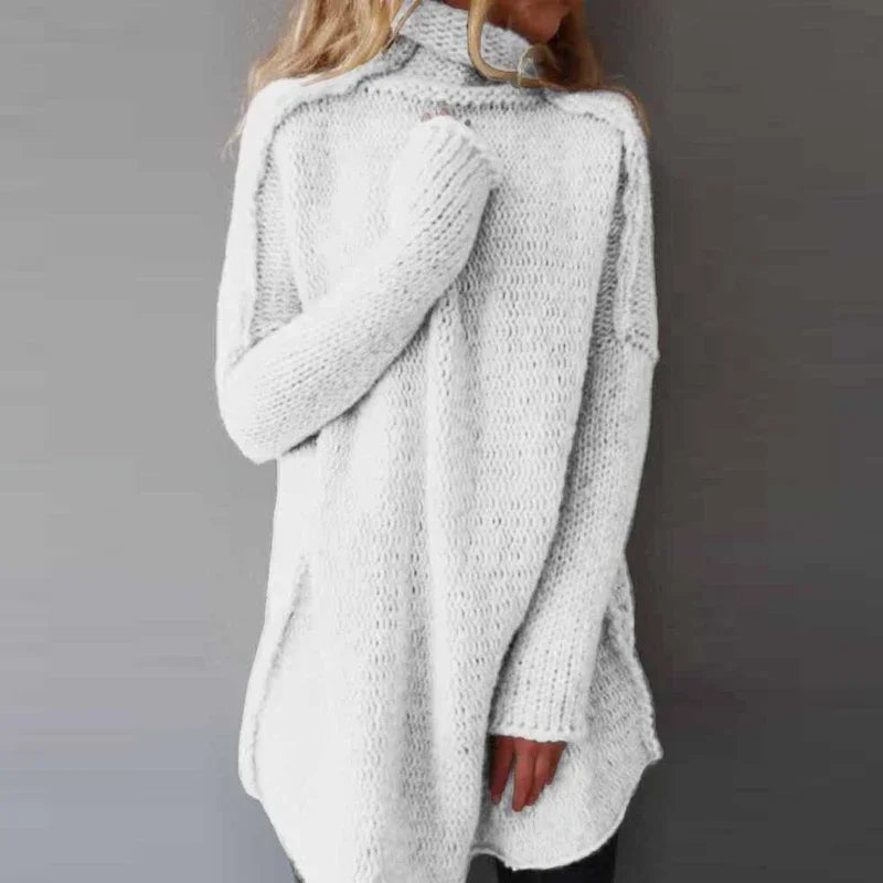 Belenza comfortabele trui in wit, met een oversized pasvorm en hoog opstaande kraag. De trui heeft een grof gebreide textuur en lange mouwen, perfect voor een warme en modieuze uitstraling tijdens koude dagen. Ideaal voor casual en cosy outfits.