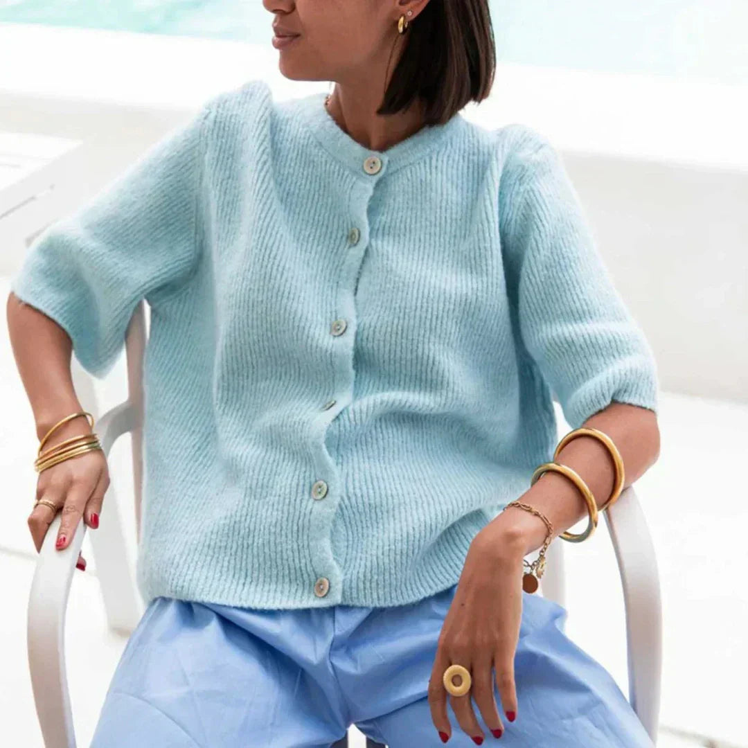 Bellorra vrouwelijk gilet in zachtblauw, met korte mouwen en een tijdloze uitstraling. Het gilet heeft een elegante knoopsluiting en biedt een comfortabele, stijlvolle look. Ideaal voor lente- en zomerdagen, perfect te combineren met luchtige broeken of rokken.