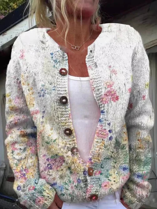 Betina cardigan met pastel bloemenpatroon, gedragen door een vrouw. De cardigan heeft een zachte, comfortabele pasvorm met een knoopsluiting en een licht gebreid design. Perfect voor een casual en stijlvolle look.