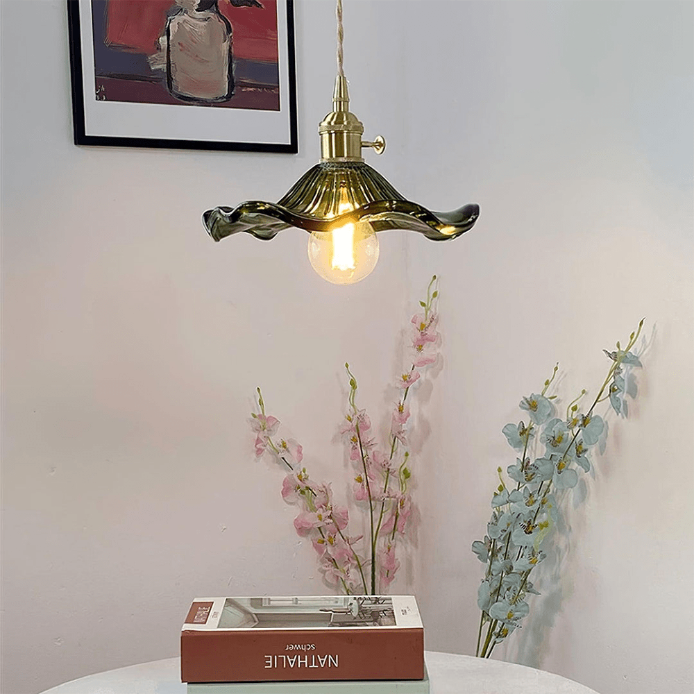 BloomLume hanglamp met een elegant golvende glazen kap in een rijke groene tint en een vintage gouden fitting. Deze stijlvolle lamp creëert een warme ambiance en is perfect voor het verlichten van woonkamers, eettafels of creatieve werkruimtes. Een natuurlijk en artistiek statement in elk interieur.
