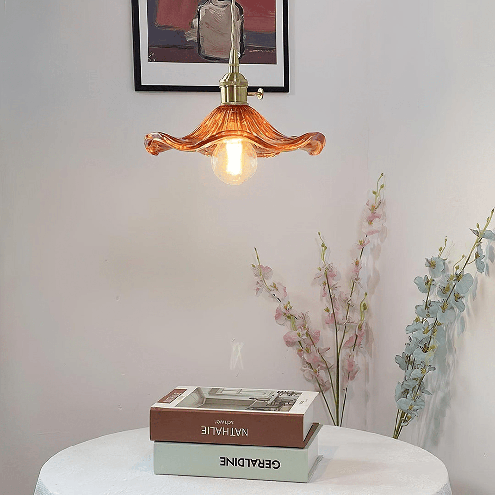 BloomLume hanglamp met een golvende amberkleurige glazen kap en een vintage gouden fitting. Deze stijlvolle lamp voegt warmte en elegantie toe aan elke ruimte, perfect voor woonkamers, eetkamers of creatieve interieurs. Een natuurlijk en artistiek accent dat verfijning uitstraalt.