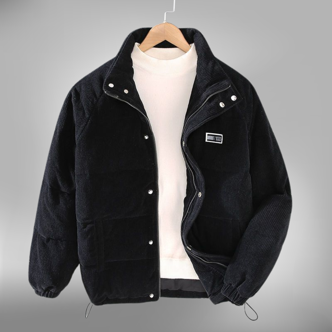 De Borealis winterjas in zwart corduroy is een perfecte combinatie van comfort en warmte. Deze gewatteerde jas heeft een praktische ritssluiting en drukknopen, evenals een subtiele merkpatch op de borst. Het ontwerp is casual en biedt optimale bescherming tegen de kou, ideaal voor dagelijks gebruik in de winter. De jas heeft een verstelbare onderrand en is zowel stijlvol als functioneel.