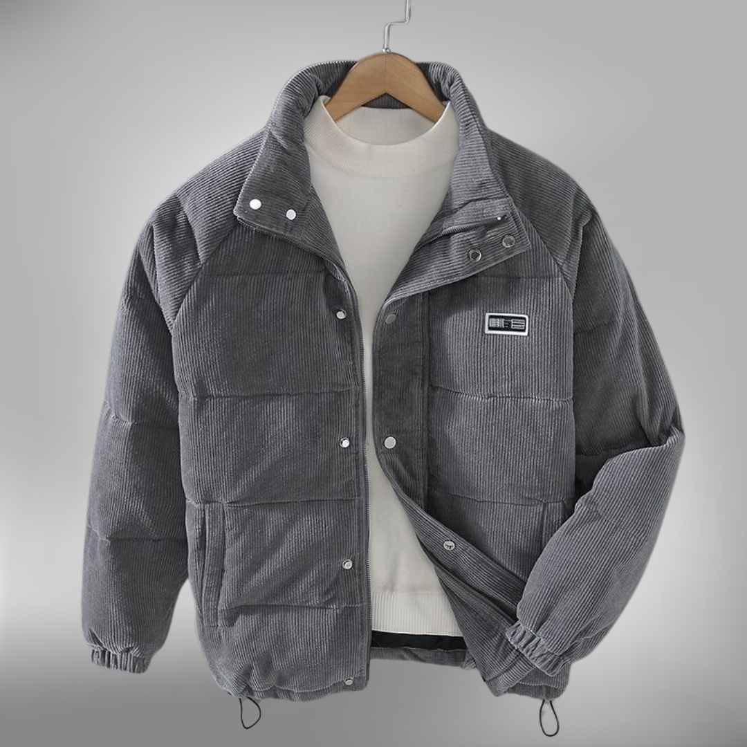 De Borealis winterjas in grijs corduroy biedt zowel warmte als stijl. Het heeft een comfortabele, gewatteerde pasvorm en een praktische ritssluiting met drukknopen. De jas is ideaal voor de koude wintermaanden, met een casual ontwerp en een subtiele merkpatch op de borst. Perfect voor dagelijks gebruik, biedt deze jas zowel bescherming tegen de kou als een modieuze uitstraling.