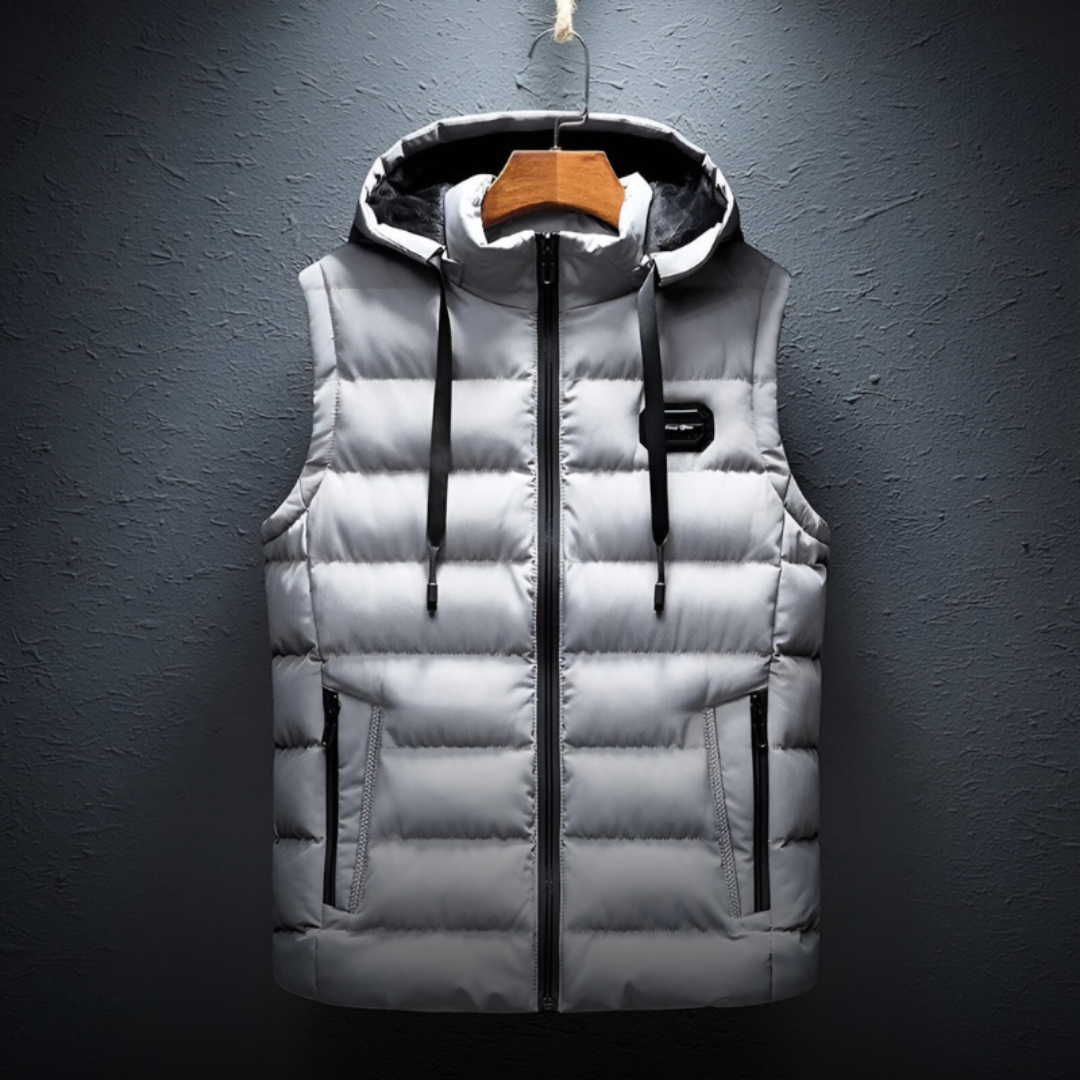 De Bostro bodywarmer in grijs biedt comfortabele isolatie en stijlvol design. Het gewatteerde materiaal houdt je warm zonder extra bulk, en de capuchon zorgt voor extra bescherming tegen de kou. De handige ritszakken bieden opbergruimte voor je essentials, terwijl de minimalistische uitstraling het perfect maakt voor zowel casual als sportieve outfits. Functioneel en praktisch, ideaal voor de koudere maanden.