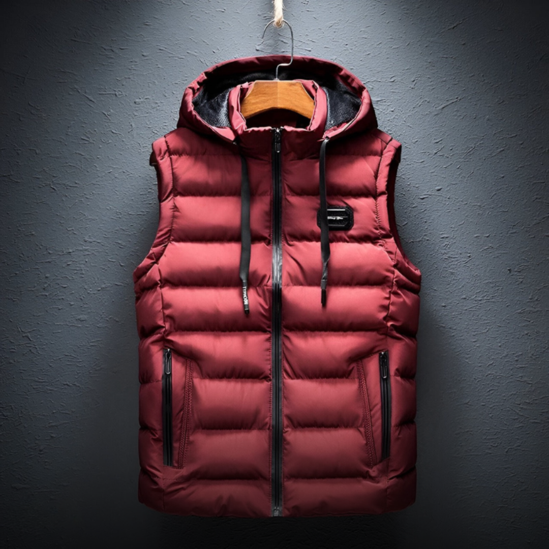 De Bostro bodywarmer in diep rood biedt ultiem comfort en bescherming tegen de kou. Het gewatteerde ontwerp zorgt voor een lichtgewicht, maar isolerende laag, terwijl de capuchon extra bescherming biedt tegen de elementen. De ritszakken zijn praktisch voor het opbergen van je spullen, en de minimalistische uitstraling maakt het de perfecte keuze voor diverse casual en sportieve outfits. Functioneel en stijlvol, ideaal voor de koudere maanden.