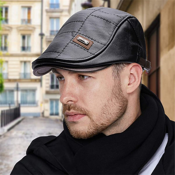 Man met een zwart leren baret van Cersoni, met een iconisch en elegant ontwerp. De baret heeft een klassieke uitstraling en is ideaal voor een modieuze, stijlvolle look, gedragen in een stedelijke omgeving.
