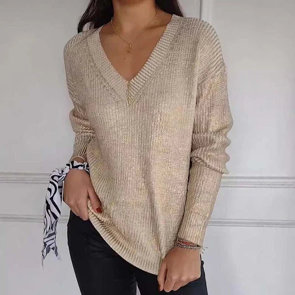 De D'Luxa metallic trui in een chique beige kleur heeft een V-hals en een glanzende textuur. Deze comfortabele trui met lange mouwen biedt zowel stijl als functionaliteit, perfect voor een trendy look.