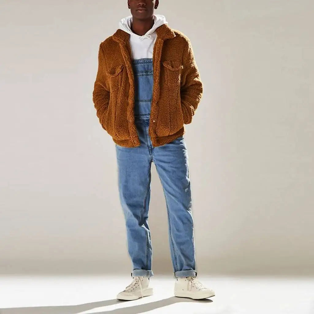 Man draagt een comfortabele, oversized teddyjas in het bruin over een blauwe denim jumpsuit. De outfit is gecombineerd met een witte hoodie en sneakers, wat zorgt voor een casual, warme en moderne look. Perfect voor een trendy, casual stijl in het herfst- of winterseizoen.