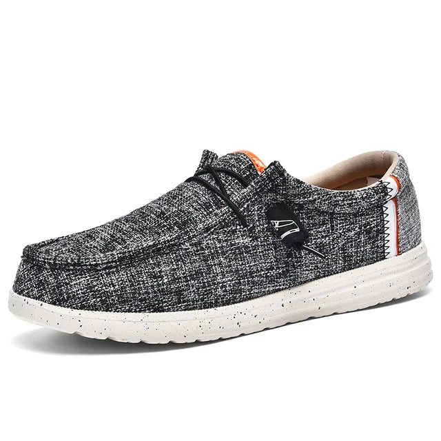 Stijlvolle grijze canvas herenschoenen met een ademende bovenkant en een zachte, flexibele zool. Deze slip-on schoenen zijn perfect voor een casual look en bieden optimaal comfort voor dagelijks gebruik. Het moderne design en de lichtgewicht constructie maken ze ideaal voor wandelen of relaxen.