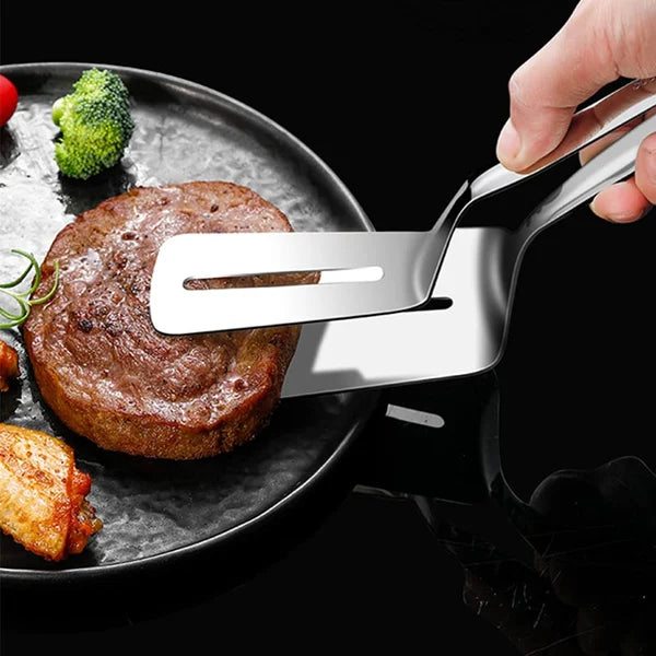 EkoFlex spatel in gebruik, tilt een perfect gebakken steak van een bord. De spatel is multifunctioneel en gemaakt van roestvrij staal. Ideaal voor grillen, bakken en serveren zonder krassen op kookgerei.