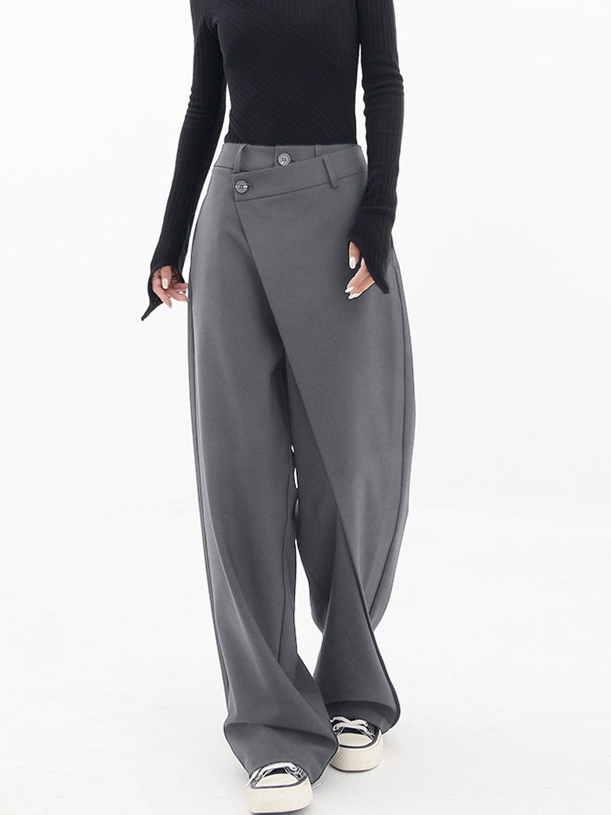 Elegante grijze wijde broek met een uniek asymmetrisch ontwerp. De overlappende voorkant en hoge taille zorgen voor een moderne en stijlvolle uitstraling. Perfect te combineren met zowel casual als chique outfits.