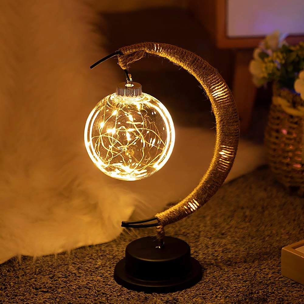De GEMYNORA maanlamp in een sfeervol interieur, met een zacht gloeien van de bol met lichtsnoeren die eruit stralen. De lamp, in de vorm van een halve maan, voegt een magische uitstraling toe aan elke kamer en creëert een rustige, betoverende sfeer, perfect voor ontspanning of decoratie.
