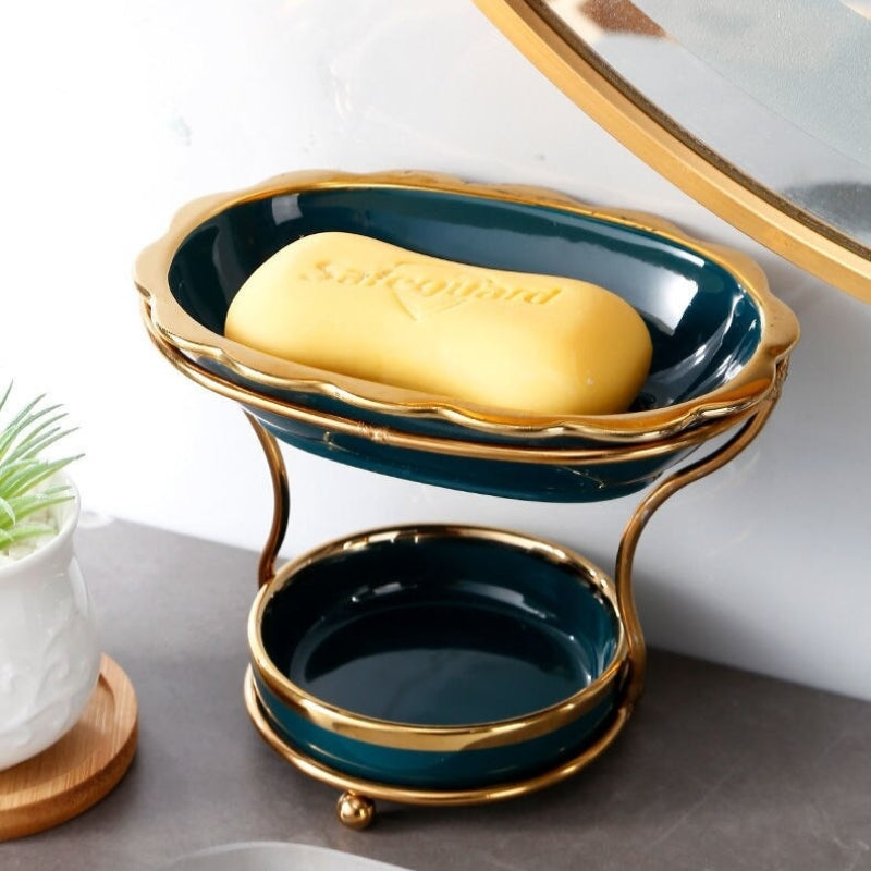 GleamEdge zeepbakje in donkerblauw met gouden accenten, geplaatst op een stijlvolle metalen standaard met twee lagen. Het moderne ontwerp biedt een elegante en praktische oplossing voor het bewaren van zeep in de badkamer.