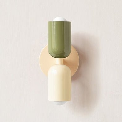 Een Deense stijl wandlamp met twee moderne lampenkappen in groene en crèmekleurige tinten, bevestigd aan een zachte, beige wandbeugel. Het strakke ontwerp voegt een eigentijdse, elegante sfeer toe aan elke ruimte.
