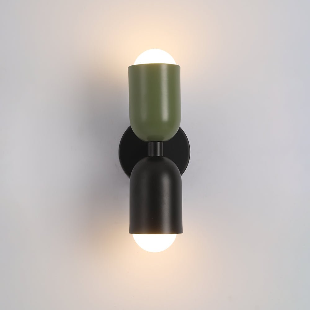 Een slanke en moderne Deense design wandlamp van Glemlux, met twee cilindrische kappen in groen en zwart, gemonteerd op een zwarte basis, die een eigentijdse en minimalistische uitstraling aan elke kamer geeft. De lamp straalt een warm licht uit, perfect voor het creëren van een elegante en stijlvolle sfeer.
