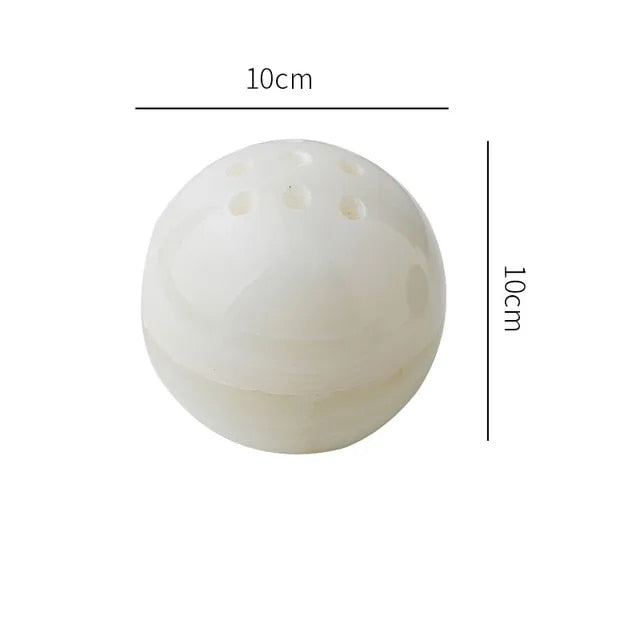 Grazia wierookhouder met rustgevend ontwerp, gemaakt van gepolijst wit marmer. De bolvormige houder heeft een diameter van 10 cm en is voorzien van meerdere gaten voor wierookstokjes. Een stijlvolle en kalmerende toevoeging aan elk interieur.