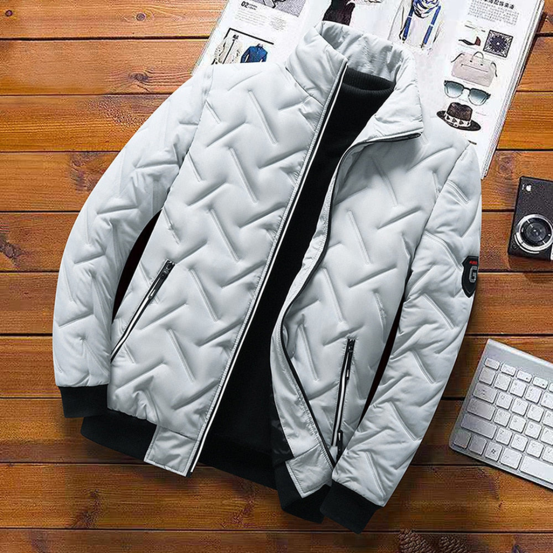 Harris Bomber Winterjas in lichtgrijs, vooraanzicht. Deze stijlvolle gewatteerde jas combineert een moderne look met warmte, ideaal voor heren tijdens koude winterdagen. Voorzien van handige zakken met ritssluiting en trendy bomberstijl.