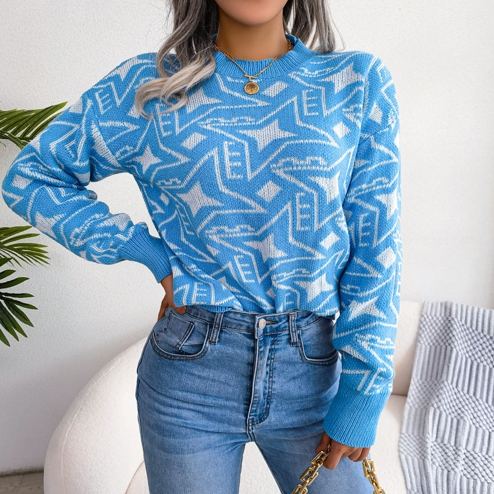Vrouw draagt de Heskari moderne trui in lichtblauw met een opvallend geometrisch patroon in wit. De trui heeft een comfortabele pasvorm en wordt gecombineerd met een jeans met hoge taille voor een trendy, casual look. Perfect voor een stijlvolle, alledaagse outfit.