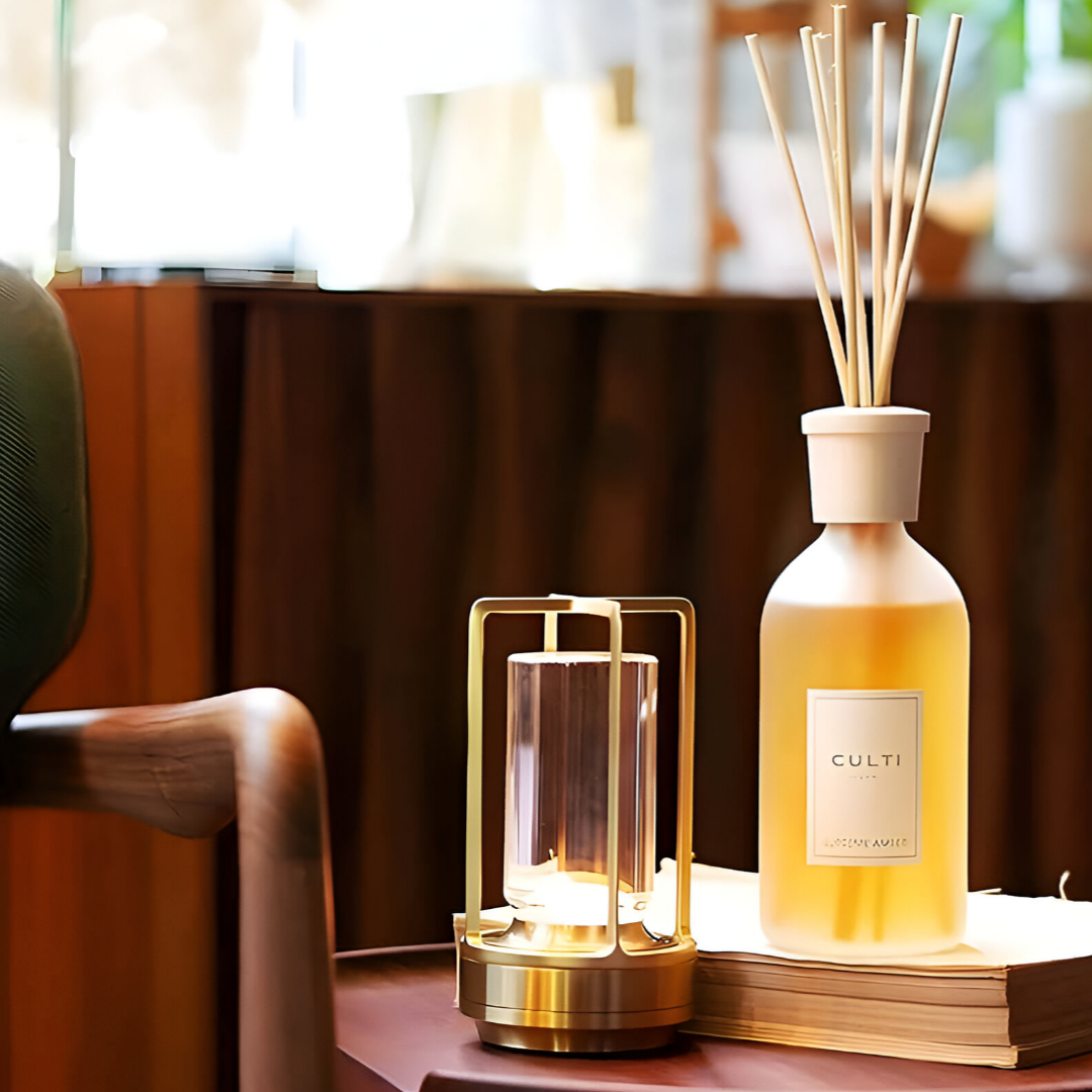 Jovien waterdichte lamp op een tafel, naast een decoratieve geurstokjeshouder, met een warme gloed die een gezellige sfeer creëert. De lamp heeft een elegante metalen afwerking en is perfect voor binnengebruik.