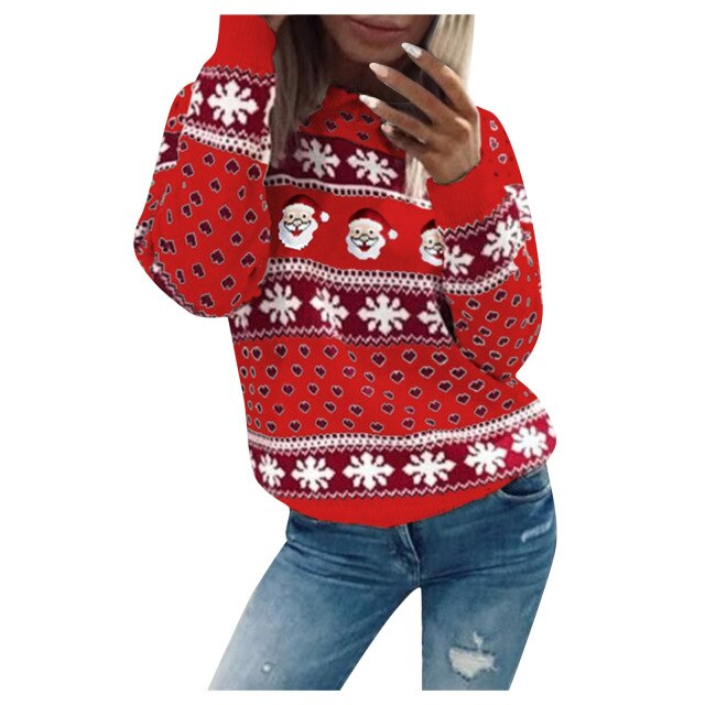 Model draagt een Kardora casual trui in felrood met een kerstmotief. De trui is versierd met kerstmannen, sneeuwvlokken en hartjes, wat een speelse en feestelijke uitstraling geeft. Perfect voor de winterperiode en kerstvieringen. Gecombineerd met een jeans voor een relaxte en modieuze look.