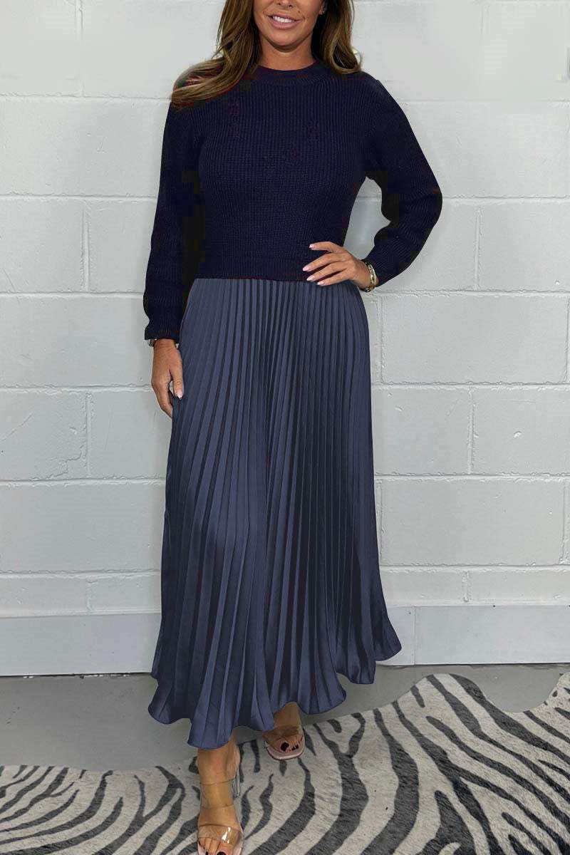 Een tijdloze pleated jurk van Kendra, met een donkerblauwe trui-top en een elegante plissé rok in een diepe blauwgrijze tint. Deze jurk heeft een verfijnde uitstraling, perfect voor zowel formele als casual gelegenheden.