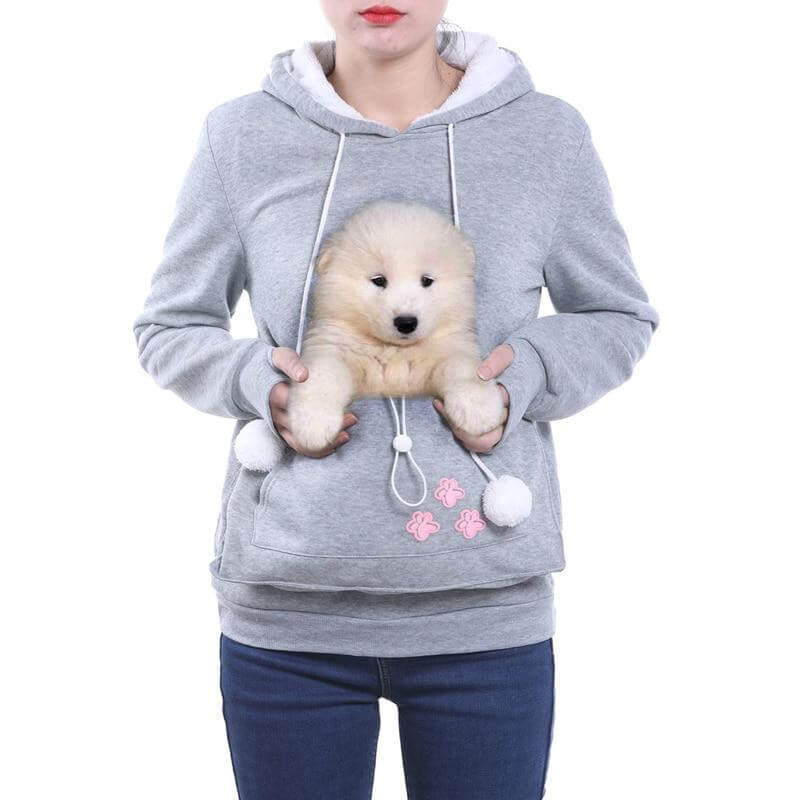 De Klaassen hoodie, een grijze trendy hoodie met een zachte buidelzak, ideaal voor het dragen van je huisdier. Voorzien van schattige roze pootafdrukken en speelse pompons, biedt deze hoodie comfort en stijl.