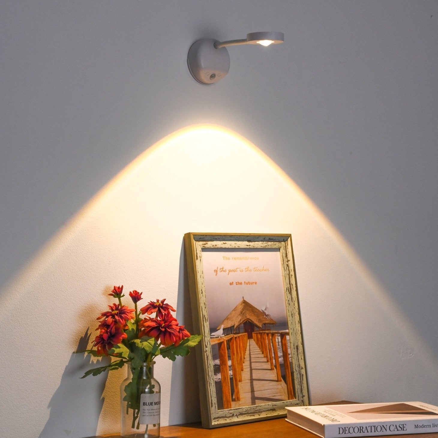 KreativX Motion Spotlight verlicht een schilderij en bloemen op een elegante manier, met slimme verlichting die een zachte, gerichte gloed creëert.