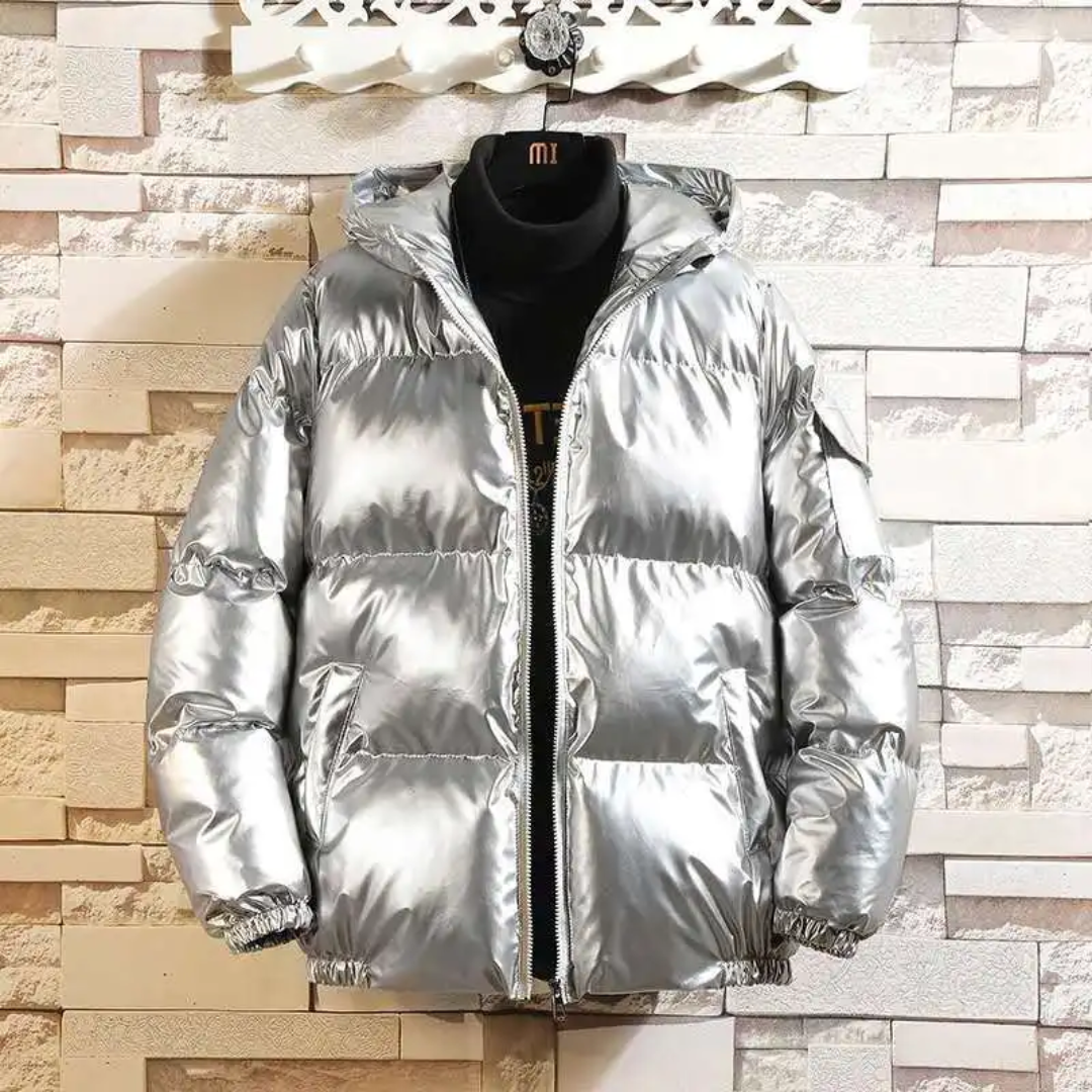 Linnora Winterjas Puffer in glanzend Zilver. Deze gewatteerde jas met capuchon combineert stijl en functionaliteit, perfect voor de koude winterdagen. Modern ontwerp met een warme, comfortabele pasvorm.