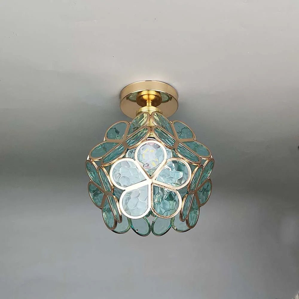 De Lumeera plafondlamp in bloemstijl combineert elegant gouden accenten met de delicate, blauwe glaselementen. Het bloemige ontwerp zorgt voor een zachte, aangename verlichting en brengt frisse charme in elke ruimte. Ideaal voor stijlvolle interieurs die een bloemige toets nodig hebben.