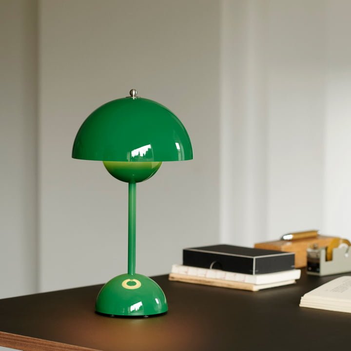De LumiNova LED-tafellamp in een levendige groene kleur, geplaatst op een strak bureau met minimalistische accessoires, perfect voor een moderne en stijlvolle werkomgeving.
