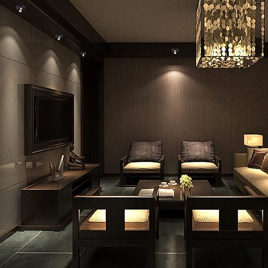 Een woonkamer met moderne en energiezuinige LumiaPro spotlights die de muur verlichten, en een luxe, gedimd interieur met een houten salontafel, stoelen en een elegante kroonluchter. Perfect voor het creëren van een stijlvolle en gezellige sfeer.