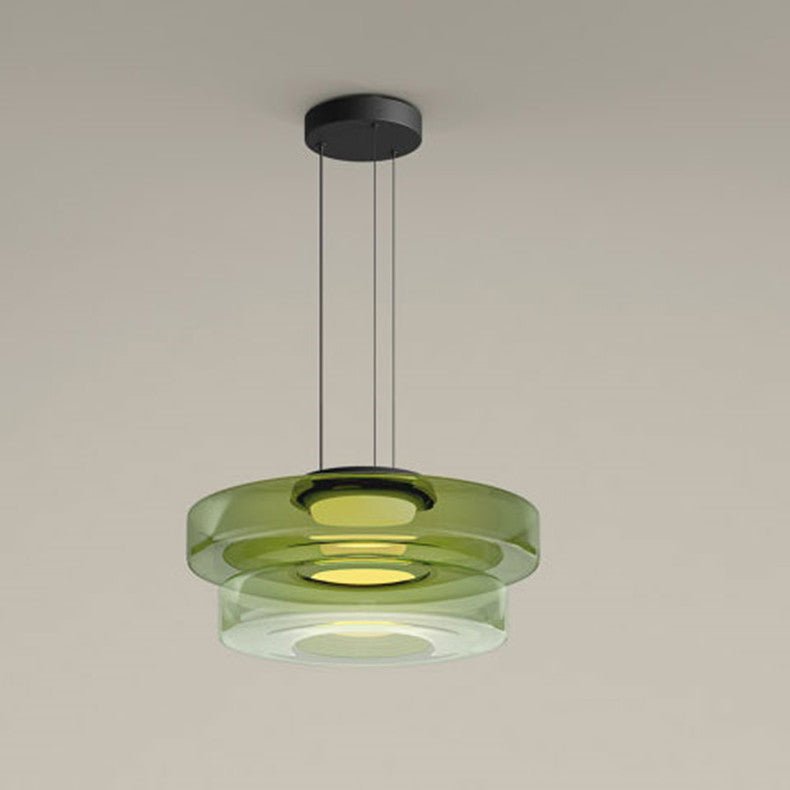 Deze moderne Bauhaus hanglamp met gestapelde groene glazen schijven biedt een strakke, minimalistische uitstraling. Het subtiele ontwerp creëert een warme, uitnodigende sfeer in je woonkamer, eetkamer of kantoorruimte. Een perfecte keuze voor wie houdt van een fusion van kunst en functionaliteit in hun interieur.