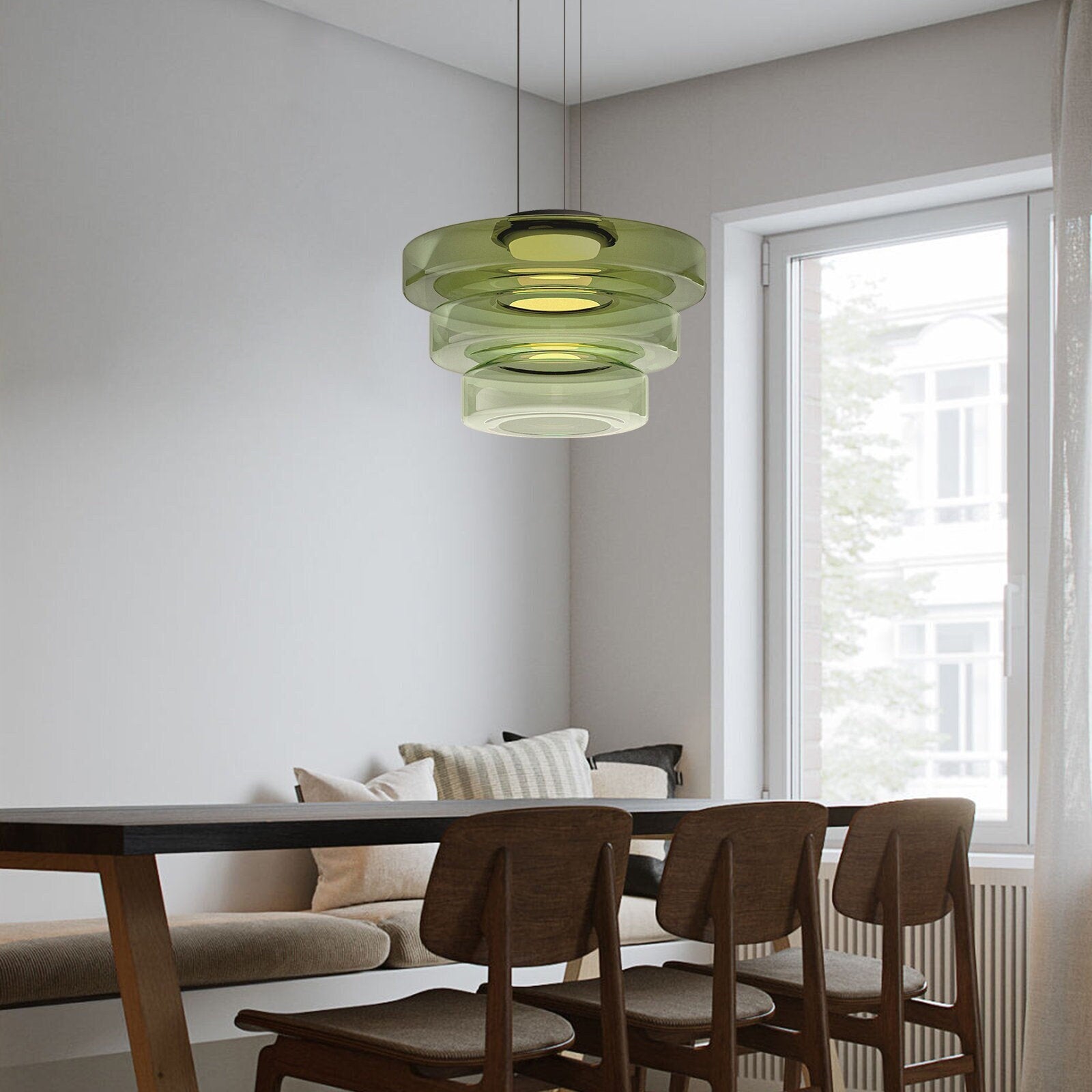 Deze stijlvolle Bauhaus hanglamp met drie gelaagde glazen schijven in een subtiele groene tint voegt een verfijnde uitstraling toe aan je eetkamer of woonkamer. Het strakke ontwerp en de zachte verlichting creëren een gezellige en moderne sfeer, perfect voor een eigentijds interieur.