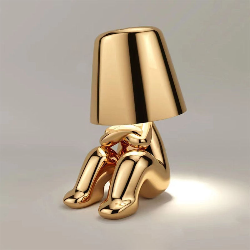Stijlvolle gouden Lumineer tafellamp met een uniek design, perfect voor flexibele verlichting en een elegante toevoeging aan elke ruimte.