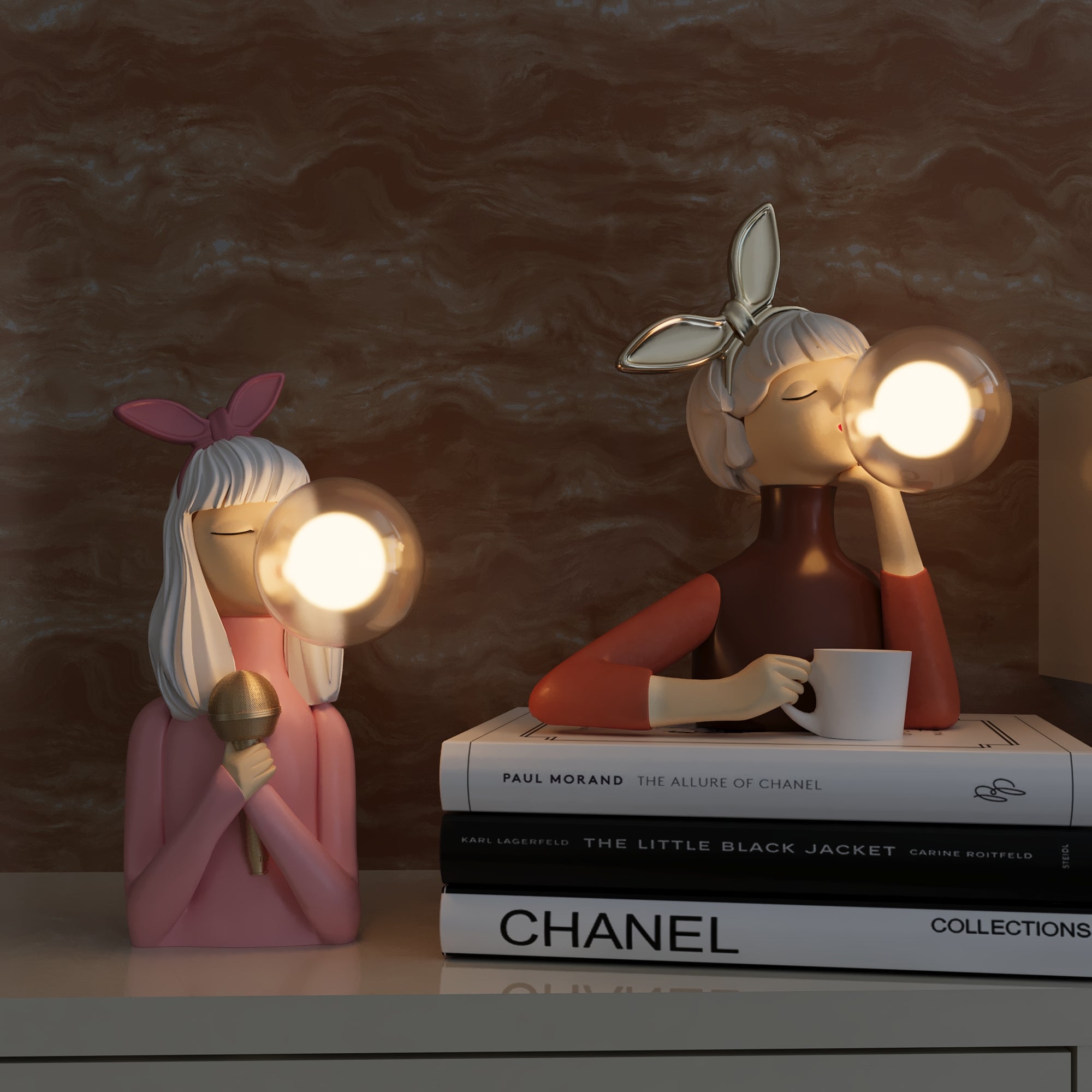 Twee Luminique tafellampen met uniek ontwerp, geplaatst op een plank met stijlvolle boeken. De lampen stralen warm licht uit en voegen een vleugje moderne elegantie toe aan uw interieur. Perfect als decoratieve en functionele verlichting.