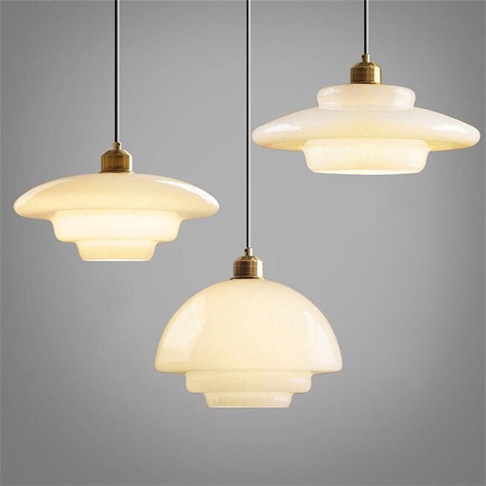 Luminova | Witte Glazen Hanglamp | Elegant - Set van drie witte glazen hanglampen met een moderne en minimalistische uitstraling. De lampen hebben unieke, afgeronde vormen en hangen aan zwarte kabels, met messing details bij de bevestiging. Deze stijlvolle hanglampen verspreiden warm, diffuus licht, ideaal voor zowel woonkamers als eetkamers