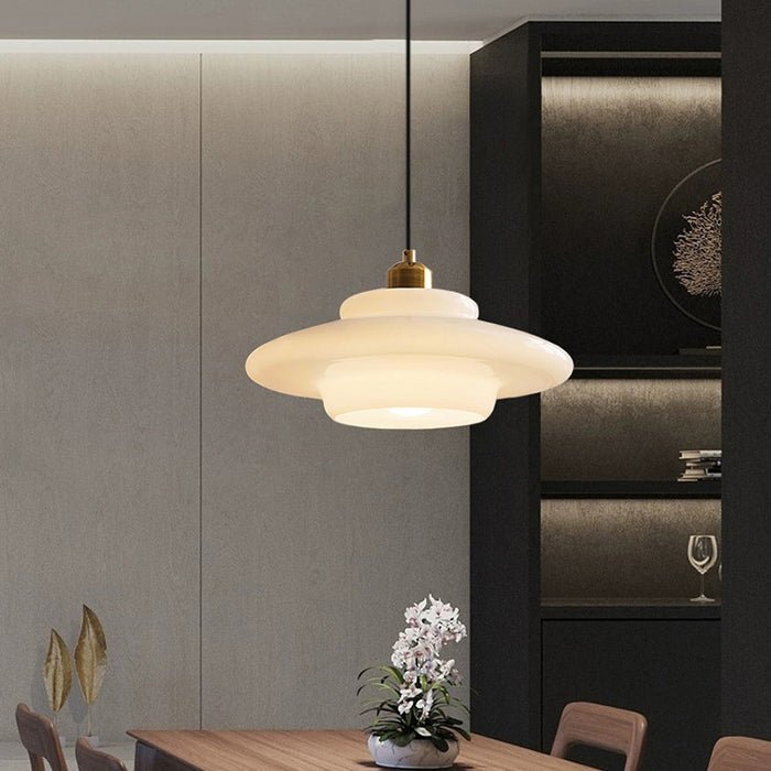 Elegante witte glazen hanglamp met een gelaagd ontwerp en gouden details. Het zachte, diffuse licht zorgt voor een warme en verfijnde sfeer in moderne interieurs. Perfect voor boven eettafels of in andere stijlvolle woonruimtes.