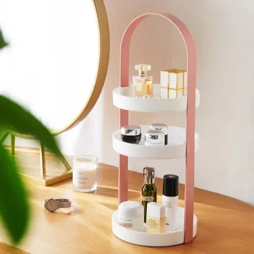 Luneva kosmetiek-organizer met drie niveaus en een stijlvolle metalen boog in zachtroze. Perfect voor het organiseren van parfum, huidverzorging en make-up. Een elegante toevoeging aan je kaptafel of badkamer.