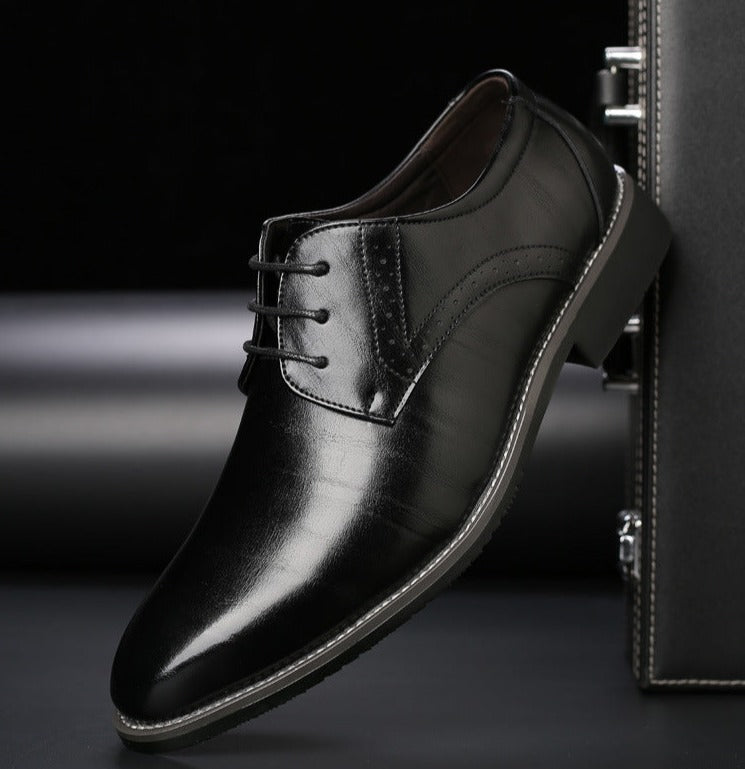 Zwarte leren herenschoenen met een glanzende afwerking, featuring een klassieke brogue-stijl met een vetersluiting. Het elegante ontwerp, met subtiele stiksels en een slanke zool, is perfect voor formele en zakelijke gelegenheden, en straalt tijdloze verfijning uit.