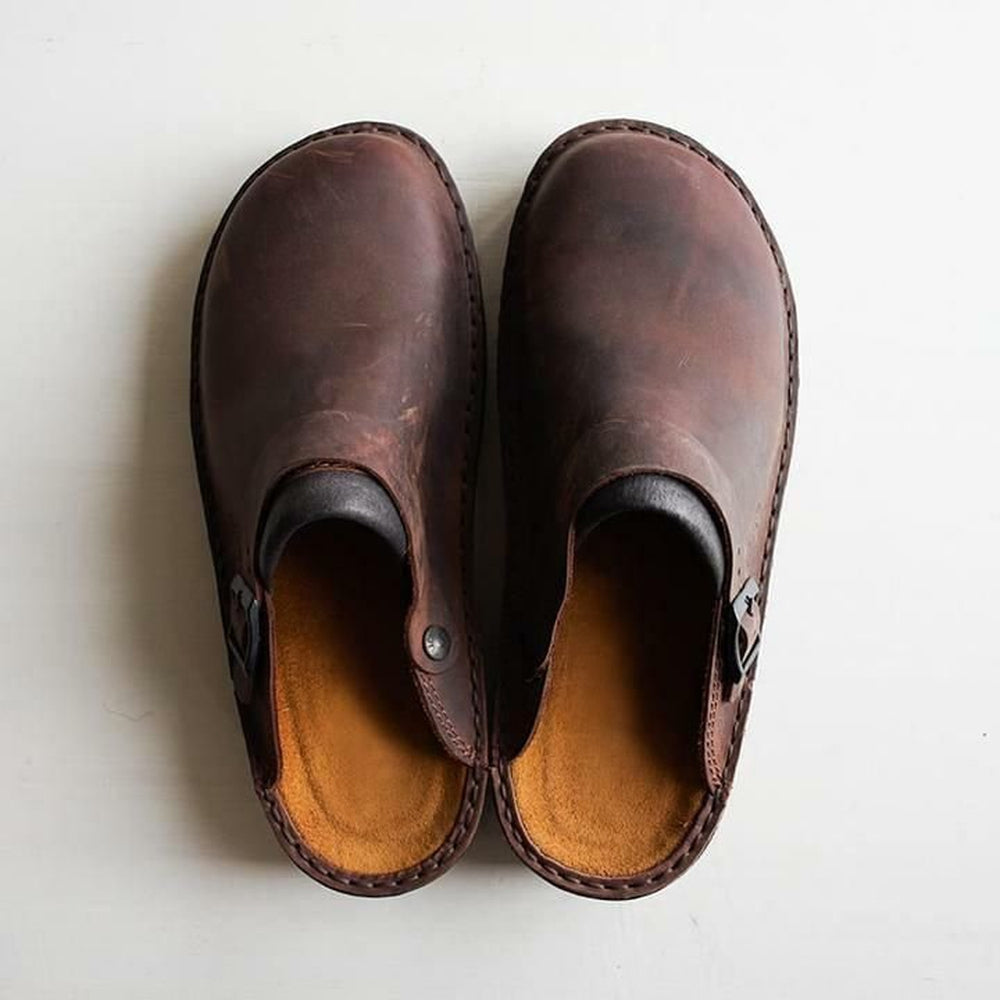 Donkerbruine leren slippers van Paxano, bovenaanzicht. Gemaakt met een verstelbare band en zacht voetbed voor optimaal comfort. Perfecte combinatie van stijl en functionaliteit.