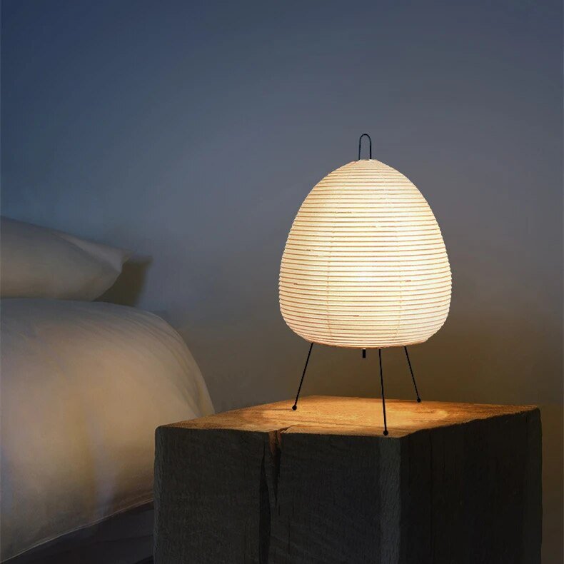De Prana lamp, met zijn unieke ovale papieren lampenkap en minimalistische metalen standaard, creëert een verfijnde en elegante sfeer. Het zachte, warme licht maakt het een perfecte toevoeging aan elk interieur, ideaal voor het toevoegen van een rustige en moderne uitstraling aan je ruimte.