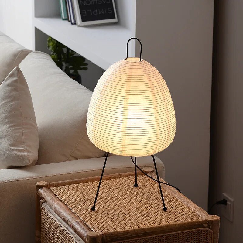 De Prana lamp, met zijn zachte papieren lampenkap en minimalistische metalen voet, biedt een verfijnde uitstraling. Het verspreidt een warm, kalmerend licht en is een stijlvolle toevoeging aan elke woonkamer, perfect voor een modern en gezellig interieur.