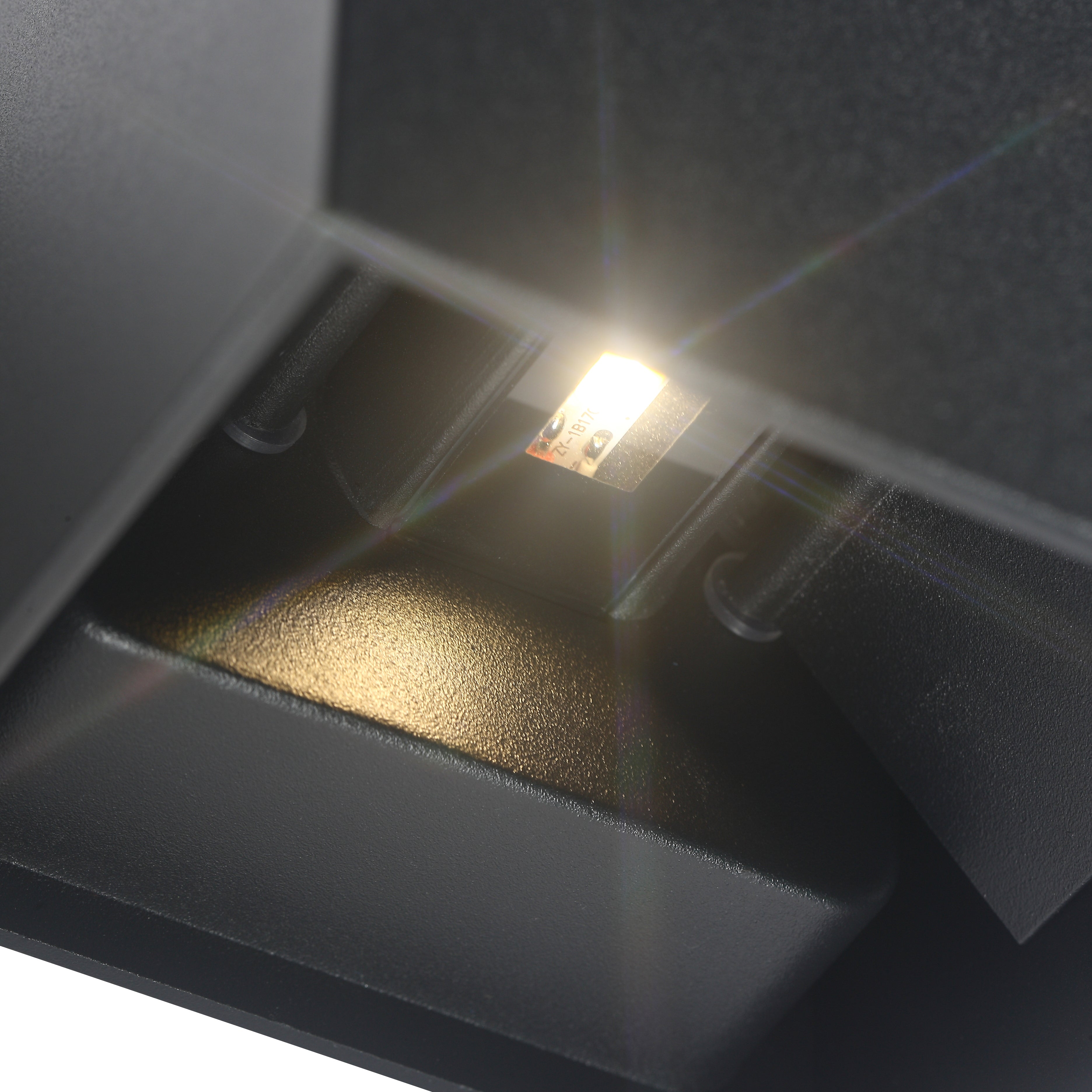 Close-up van de LED-verlichting binnen de Quinova wandlamp, met een helder licht dat uitstraalt van een klein, ingebouwd LED-paneel in een strakke, vierkante zwarte behuizing.
