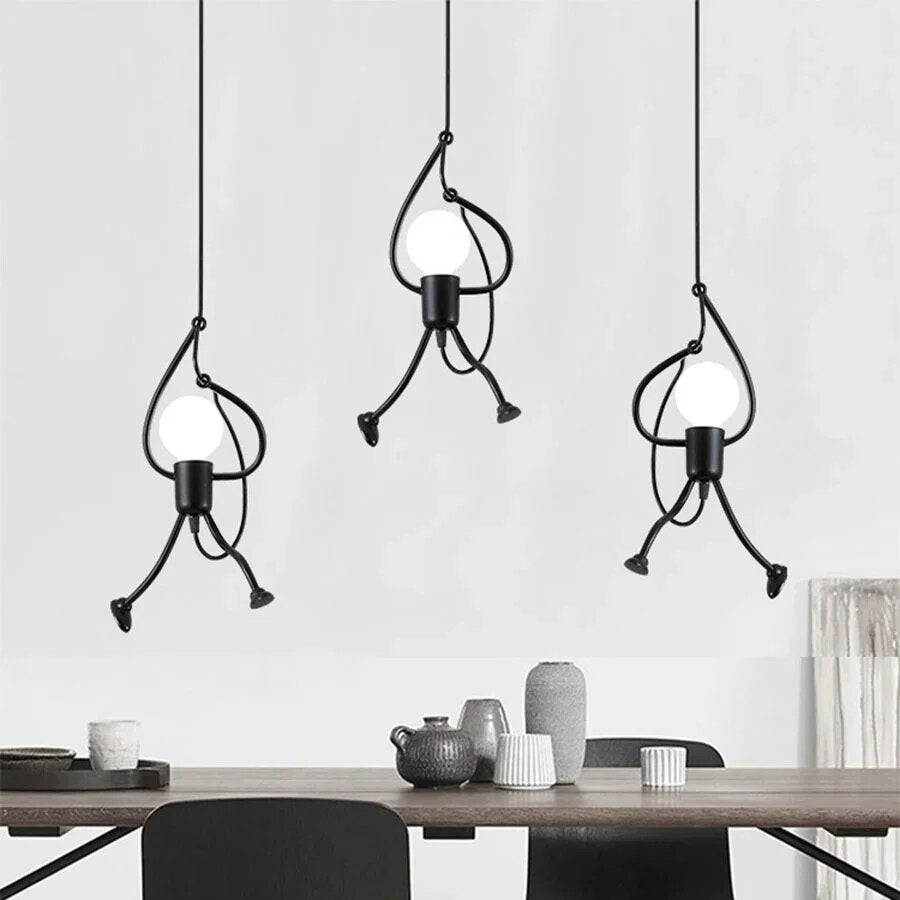 Set van drie industriële hanglampen in de vorm van speelse figuren die gloeilampen vasthouden, ideaal voor een moderne eetkamer of keuken.