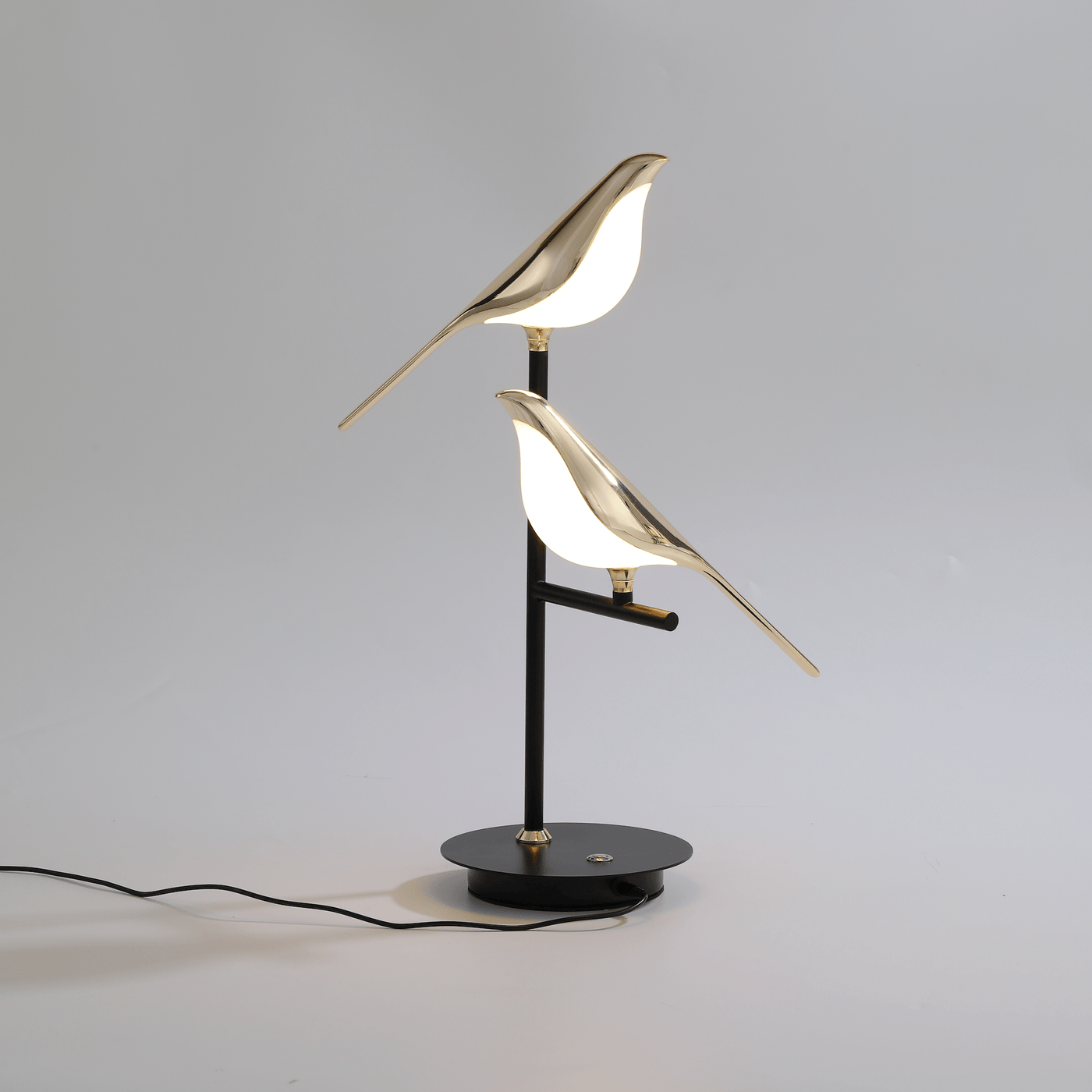 Sprankelum LED Tafellamp | Elegant ontwerp met twee goudkleurige vogels die sfeervol licht uitstralen. De zwarte metalen basis biedt een moderne uitstraling die perfect past in elke interieurstijl, ideaal voor een verfijnde touch in uw woonkamer of werkruimte