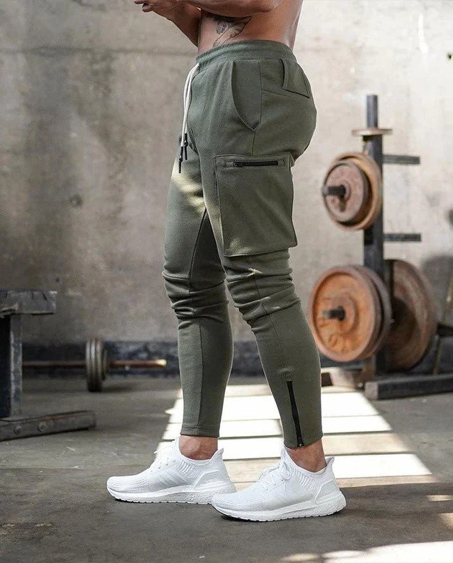 Afbeelding van de Umiro cargo jogger in een stijlvolle legergroene kleur. Deze comfortabele jogger heeft een slim-fit pasvorm en is voorzien van praktische cargozakken met ritssluiting voor extra opbergruimte. De elastische tailleband met trekkoord zorgt voor een perfecte pasvorm, terwijl het zachte, flexibele materiaal ideaal is voor sportieve en casual gelegenheden.
