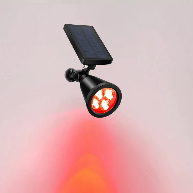 Een energiezuinige tuinlamp met een zwart zonnepaneel en vier rode LED-lampen. De lamp straalt een warme rode gloed uit en is ontworpen om buitenruimtes duurzaam te verlichten met zonne-energie.